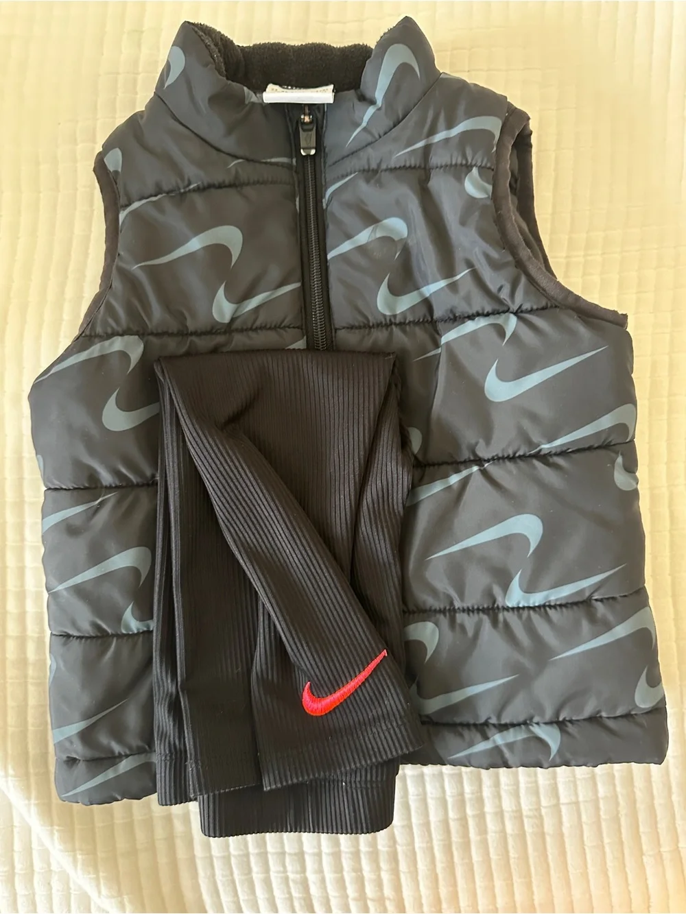 Nike Black Puffer Vest with Light Blue Swoosh and Black Leggings